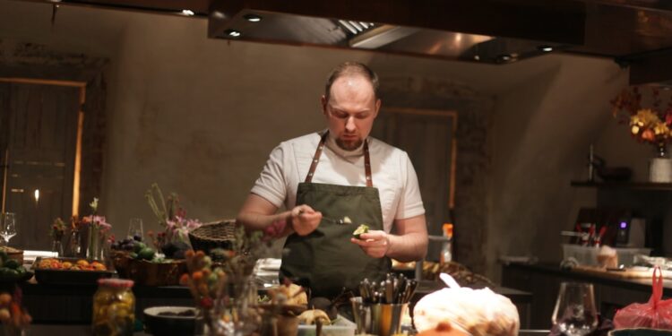 Un chef en train de préparer un Sunday roast autour d'une table dans un cosy gastropub londonien