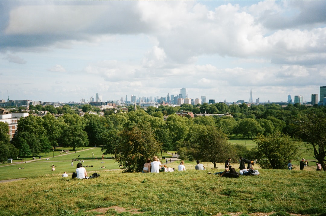 Two children running and laughing across the open lawns of London parks on a bright summer day