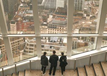 A couple visiting a residential property with an estate agent, discussing the space during a buy-to-let flat viewing in Londo