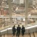 A couple visiting a residential property with an estate agent, discussing the space during a buy-to-let flat viewing in Londo