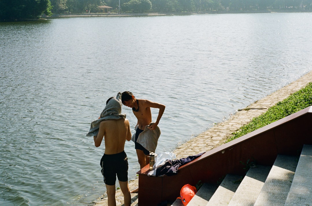 2 friends wrapping up in towels and smiling after a wild swimming session at a London reservoir