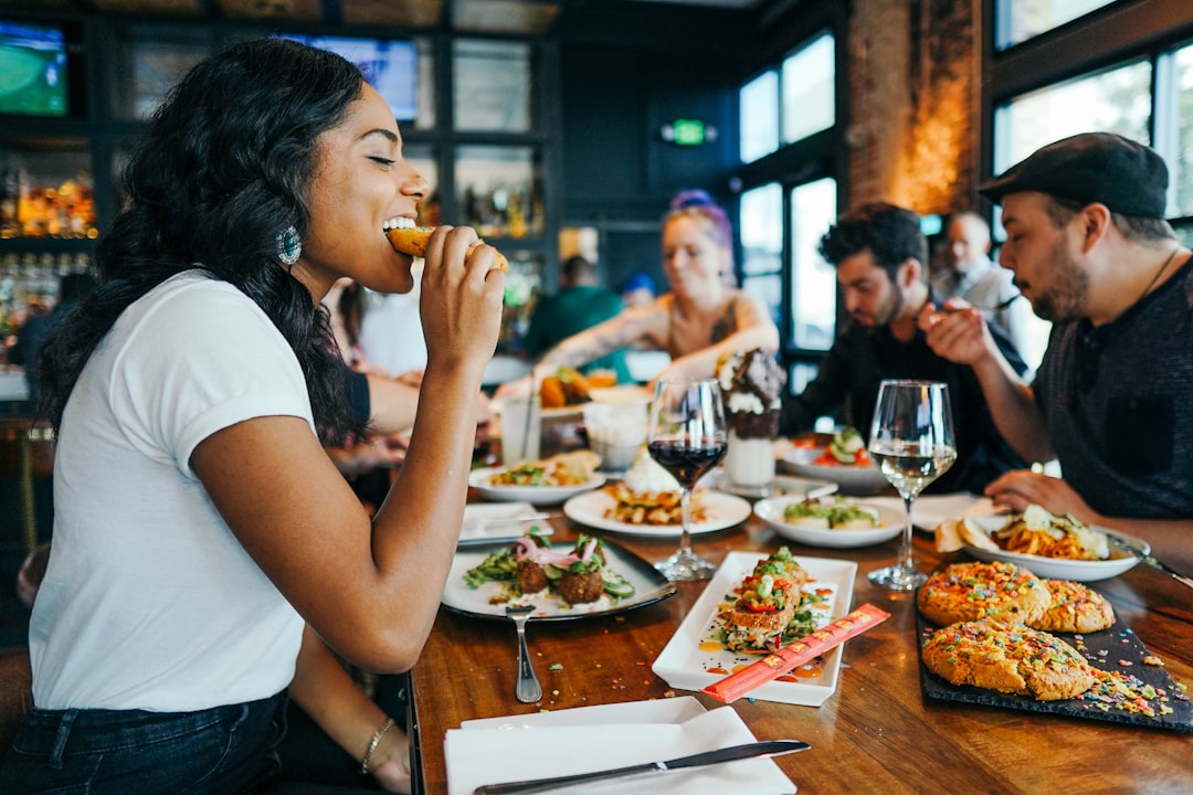 A diverse group of friends sharing dishes at a table inside one of London's multicultural neighbourhoods restaurants