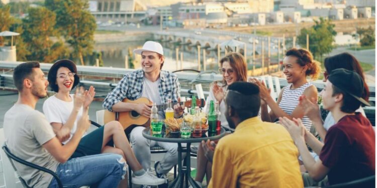 A group of friends enjoying an alfresco lunch on a sunlit terrace in London, raising glasses over a seasonal spread