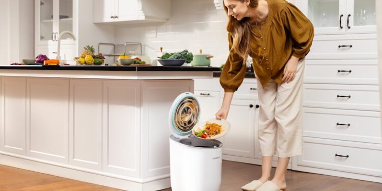 woman-recycling-kitchen-unsplash - LONDONwebzine A woman carefully sorting household waste into recycling bins in a small London flat kitchen