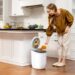 woman-recycling-kitchen-unsplash - LONDONwebzine A woman carefully sorting household waste into recycling bins in a small London flat kitchen