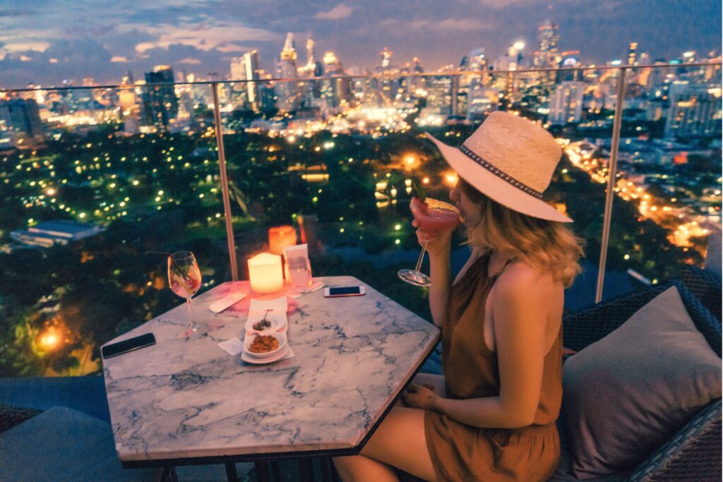 young woman drinking on rooftop restaurant in London