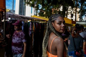 A Ghanaian community market trader in London arranges traditional fabric and food at an outdoor stall