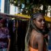 black-woman-market-vendor-unsplash - LONDONwebzine A Ghanaian community market trader in London arranges traditional fabric and food at an outdoor stall