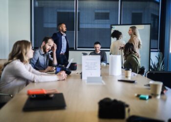 An early-stage founder presents her business plan to investors inside a City of fintech accelerators programme boardroom.