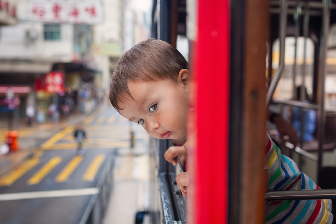 A curious child sits in a vintage bus cab as part of a rainy day London outing at the London Transport Museum
