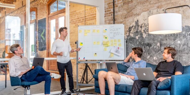 founder-presenting-pitch-investors-meeting-unsplash - LONDONwebzine A London startup founder presents a pre-seed funding pitch to a group of angel investors in a modern meeting room