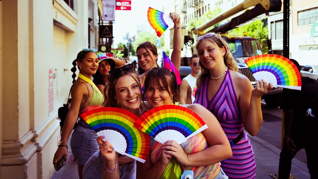A group of friends smiling and walking through Soho during Pride in London celebrations