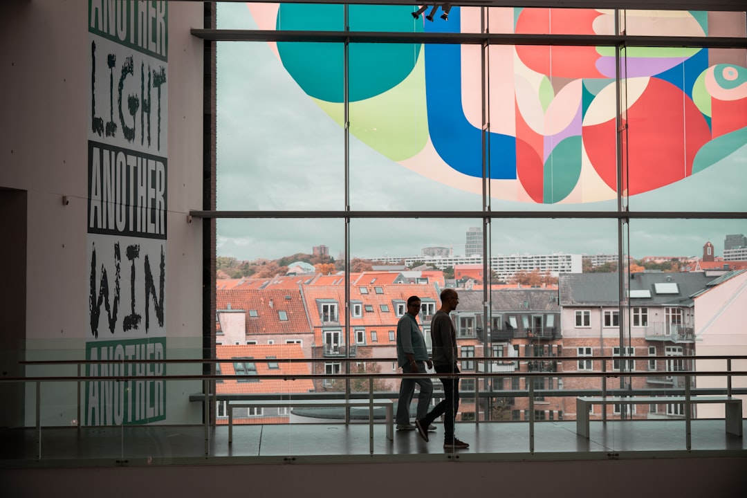 Visitors walk through a gallery space at the London Design Biennale, discovering international pavilions at Somerset House.
