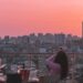people-in-rooftop-cocktail-party-unsplash - LONDONwebzine A woman enjoying cocktails at one of London's rooftop bars with the city skyline in the background on a summer evening.