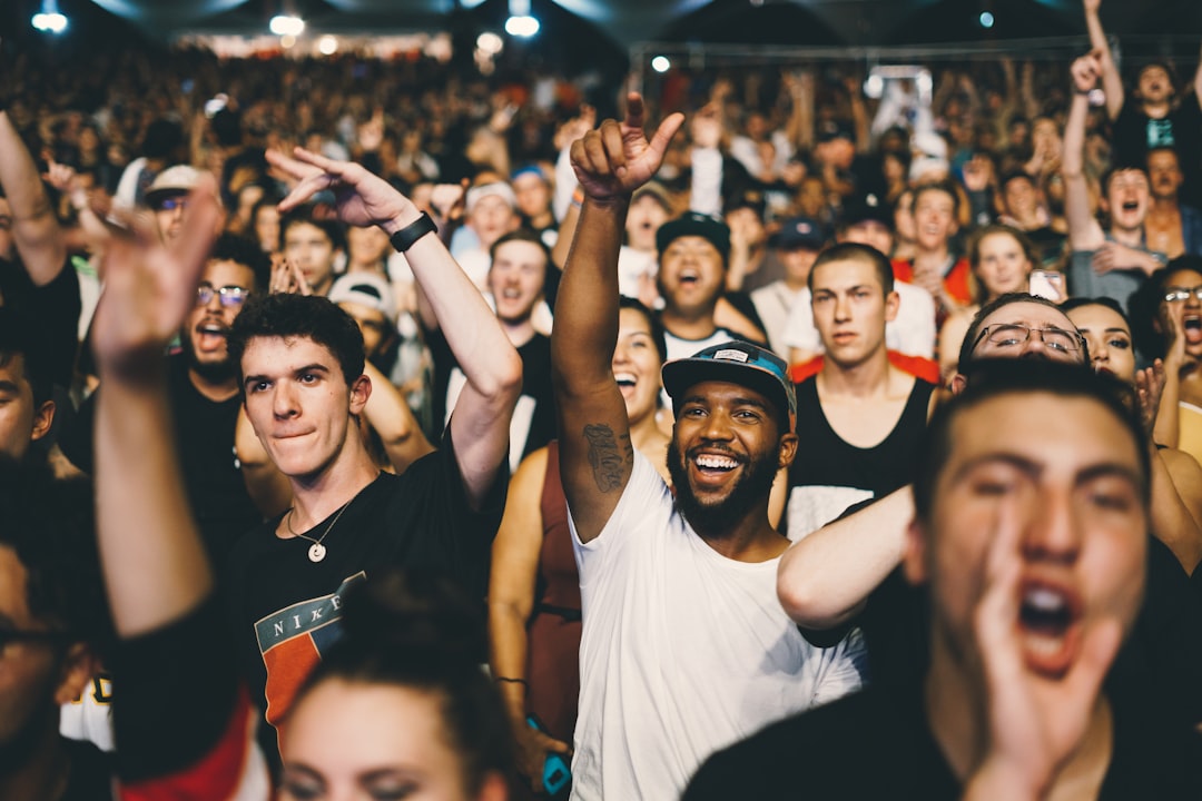 A group of people stands together in an arena at a Proms tickets performance, enjoying the music from close range