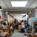 person-shopping-vintage-furniture-shopping-unsplash - LONDONwebzine A man examining second-hand chairs at a London warehouse, exploring ethical furniture sourcing in the city.