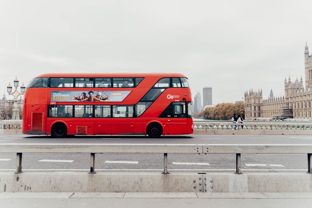 A visitor on the upper deck of a London bus enjoying a budget London city tour