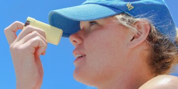 woman-applying-sunscreen-unsplash - LONDONwebzine A woman applying skin protection SPF on her face on a sunny London street