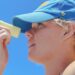 woman-applying-sunscreen-unsplash - LONDONwebzine A woman applying skin protection SPF on her face on a sunny London street
