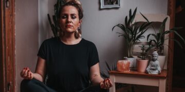 A woman practising conscious breathing in one of London's leading breathwork studios, lying on a mat in a softly lit room.