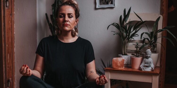 A woman practising conscious breathing in one of London's leading breathwork studios, lying on a mat in a softly lit room.