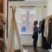 woman-browsing-ethical-boutique-rails-unsplash - LONDONwebzine A woman carefully browsing a curated rail of slow fashion garments inside a small London boutique