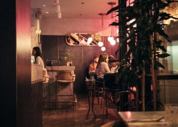 A woman enjoying exclusive dining at one of London's top members clubs, surrounded by elegant interiors