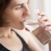 woman-drinking-water-morning-unsplash - LONDONwebzine A woman starting her morning routine with a glass of water before the London heat builds outside her window