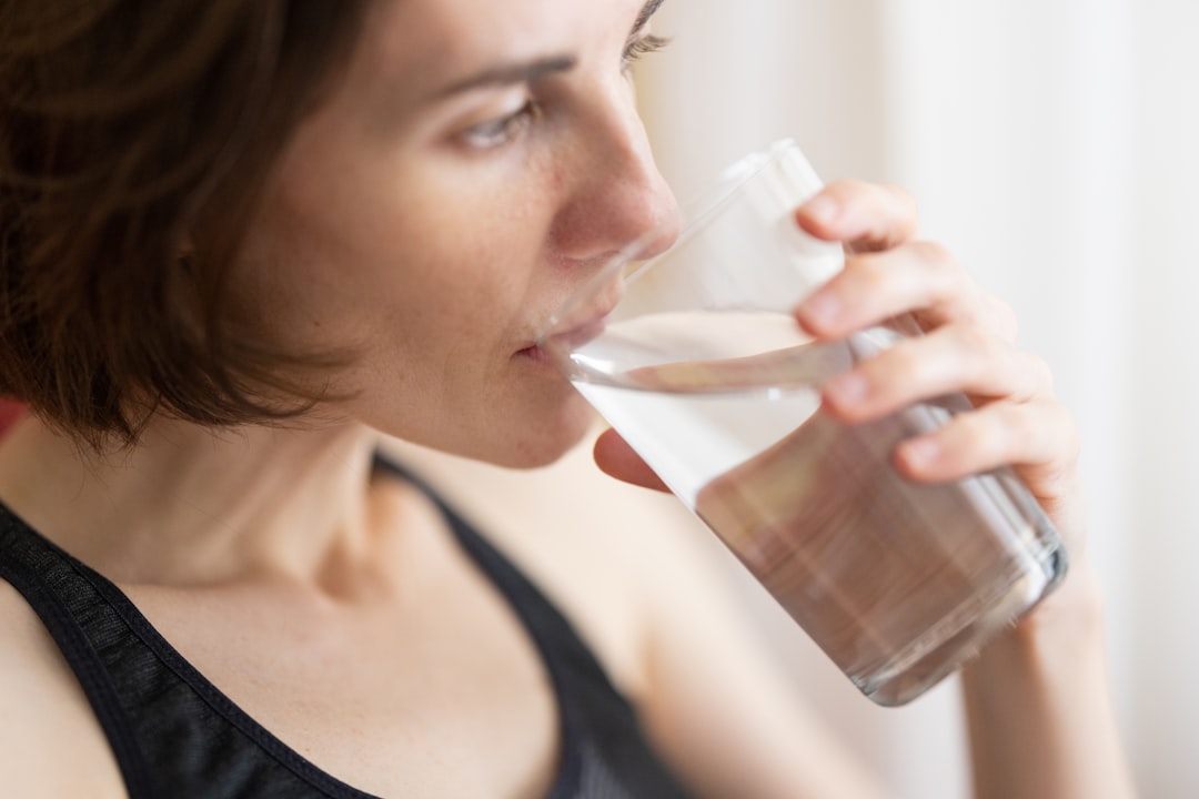 A woman staying hydrated to support her skin protection routine during a summer heatwave