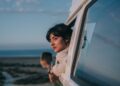 woman-in-car-window-seaside-unsplash - LONDONwebzine A woman looks out of a car window as she travels toward one of the coastal escapes from London on a bright summer afternoon.