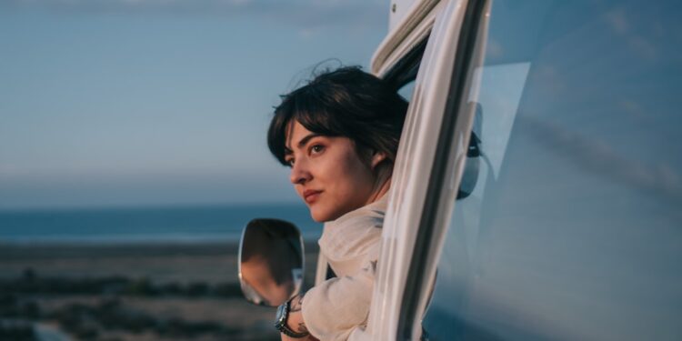 woman-in-car-window-seaside-unsplash - LONDONwebzine A woman looks out of a car window as she travels toward one of the coastal escapes from London on a bright summer afternoon.