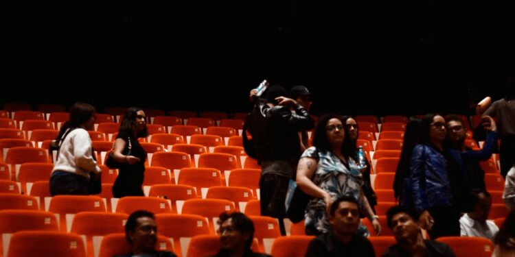woman-in-concert-hall-unsplash - LONDONwebzine A woman smiles in the audience at the BBC Proms tickets event inside a grand Victorian concert hall