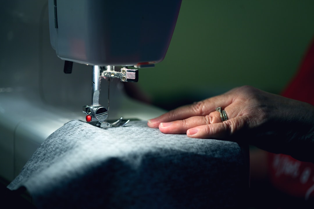 A woman repairing a garment at a London repair, extending the life of her sustainable wardrobe through hands-on care