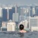 woman-swimming-rooftop-pool-city-view-unsplash - LONDONwebzine A woman swimming in one of London's rooftop pools with the city skyline visible through floor-to-ceiling windows
