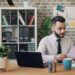 business-owner-reviewing-lease-documents-unsplash - LONDONwebzine A business owner carefully reviewing a commercial lease agreement in a bright London studio space