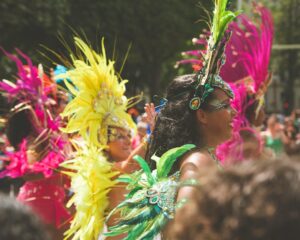A costumed dancer performing at Notting Hill Carnival in front of crowds on Ladbroke Grove