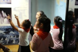 A young girl reaches out to touch a dinosaur fossil display inside one of London's top children's museums