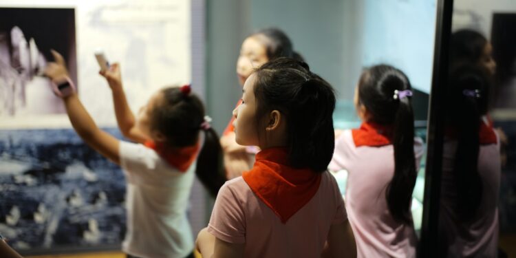 children-museum-unsplash - LONDONwebzine A young girl reaches out to touch a dinosaur fossil display inside one of London's top children's museums
