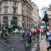A group of beginners setting off on a road cycling club ride through a London park on a sunny morning
