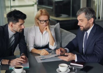 A financial advisor in a London office explains how to open a stocks ISA to a client across the desk