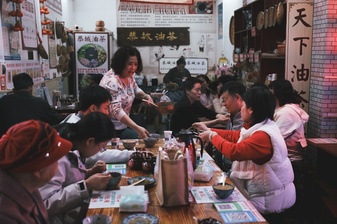 A group of friends gathered around a table covered in dim sum dishes at a London teahouse