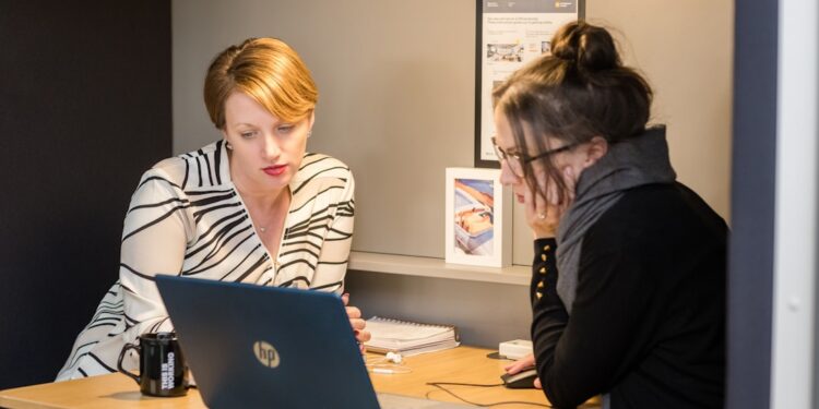 A London finance director conducts a business audit at her office desk in the City, reviewing financial records before Q4.
