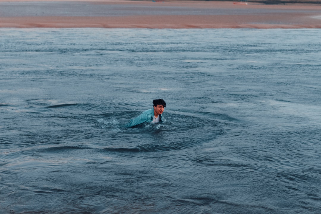 A man wrapping up in a towel after cold water swimming at an East London open water venue