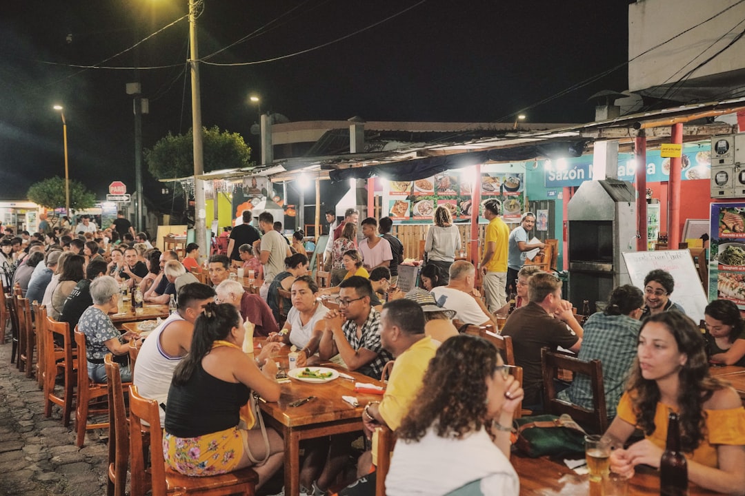 A group of friends share plates of street food at Brixton Village, celebrating the diverse street food of south London.