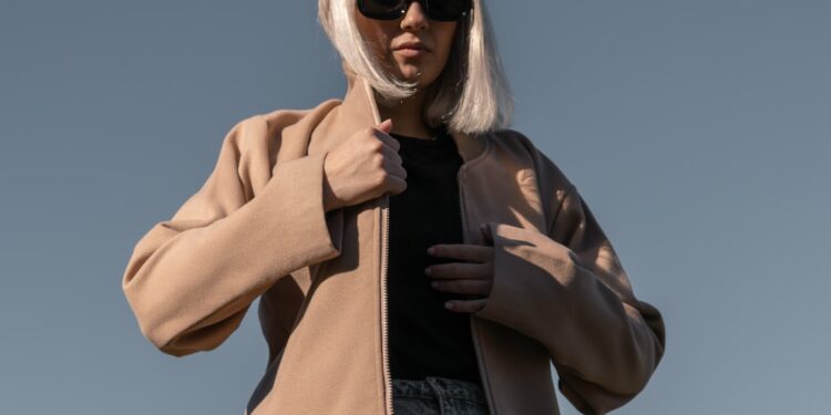 A woman in London adjusts her jacket layers, ready for a day of unpredictable August wear in the city.