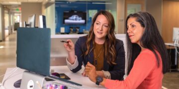 professional-mentor-advising-entrepreneur-office-unsplash - LONDONwebzine An experienced business mentor in London reviews a startup plan with a young founder at a desk