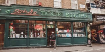 shopping-bookstore-unsplash - LONDONwebzine A woman carefully browses shelves inside one of London's independent bookshops on a summer afternoon