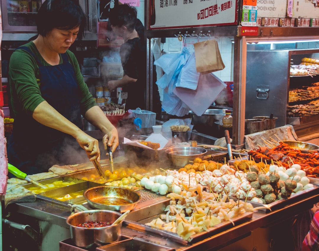 A woman enjoys diverse street food from a Camden Market stall, sampling the global flavours in London's street food.