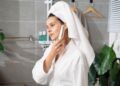 woman-applying-face-cleanser-bathroom-unsplash - LONDONwebzine A woman applying a minimal skincare cleanser at her bathroom mirror, representing a simple London indie beauty routine