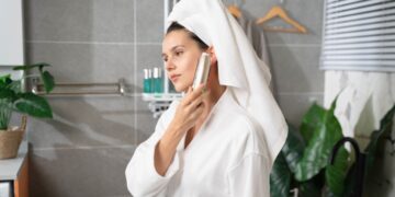 woman-applying-face-cleanser-bathroom-unsplash - LONDONwebzine A woman applying a minimal skincare cleanser at her bathroom mirror, representing a simple London indie beauty routine